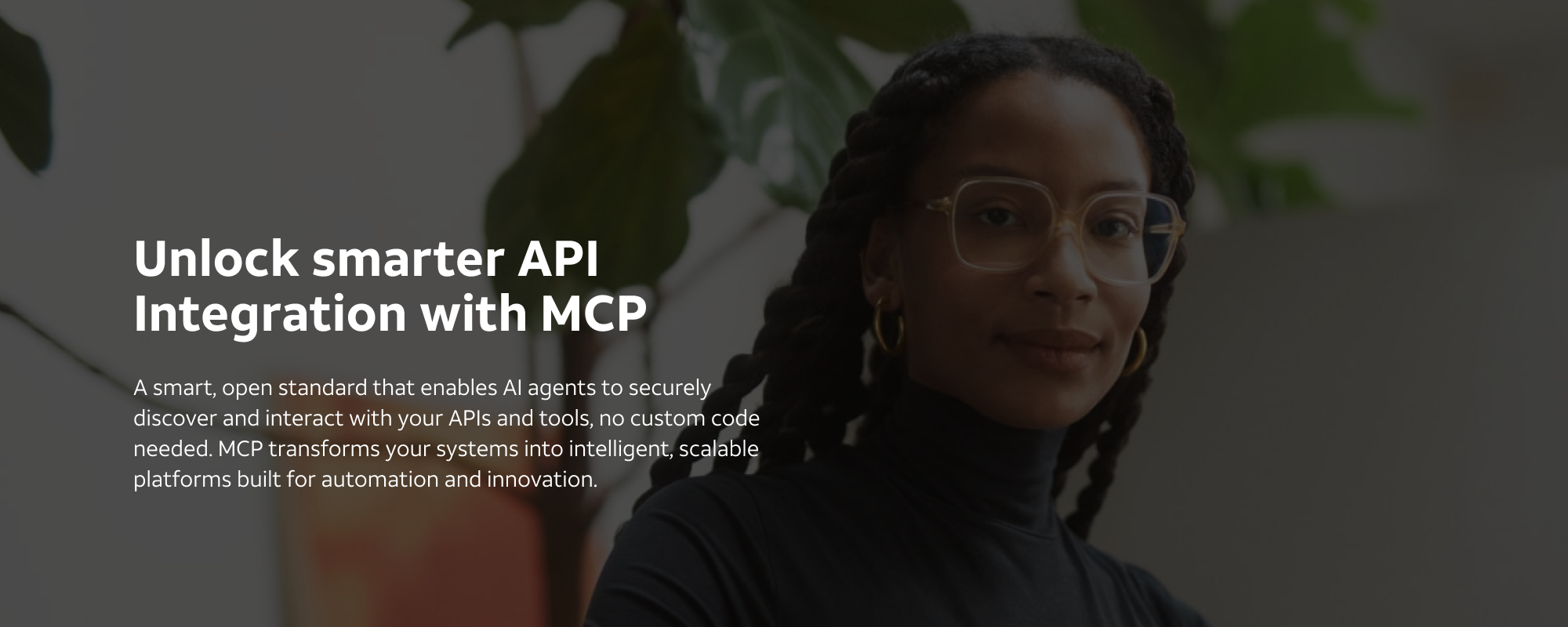 Woman in front of plants. Caption reads "Unlock smarter API Integration with MCP - A smart, open standard that enables AI agents to securely discover and interact with your APIs and tools, no custom code needed. MCP transforms your systems into intelligent, scalable platforms built for automation and innovation".